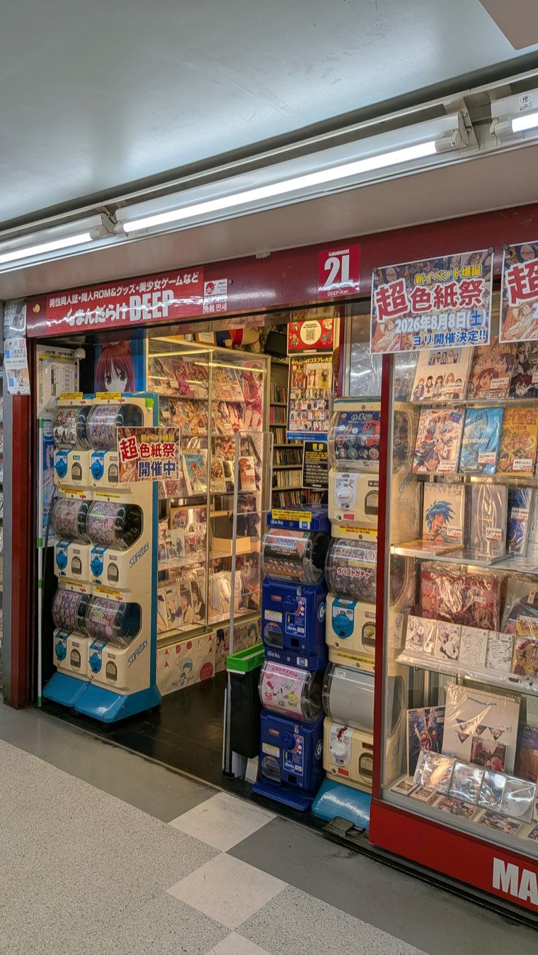 Rote Ladenfront von Mandarake DEEP-kan mit einem Schild, das Doujinshi- und Bishoujo-Spiele-Kategorien auf Japanisch auflistet