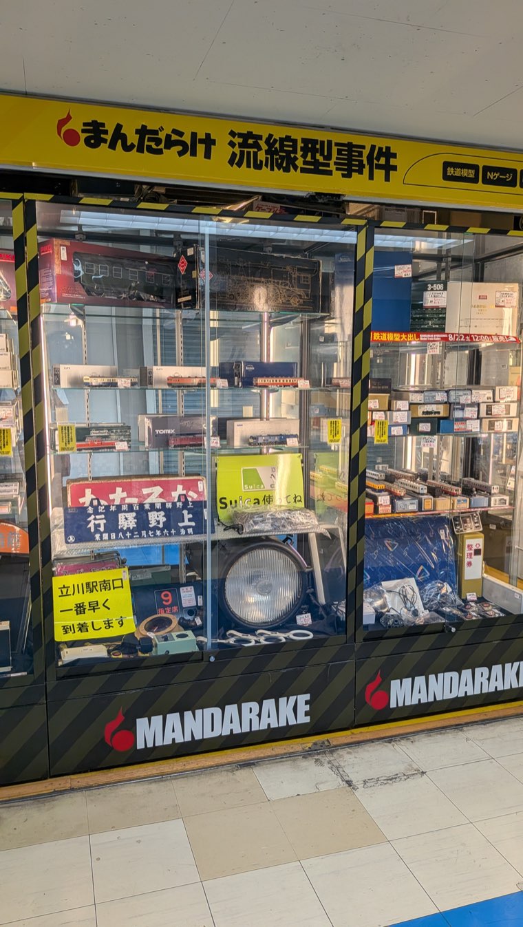 Ladenfront von Mandarake Ryusenkei Jiken im 4. Stock, gelbes Schild mit 流線型事件 und Vitrinen mit Modellbahnen in Spur N